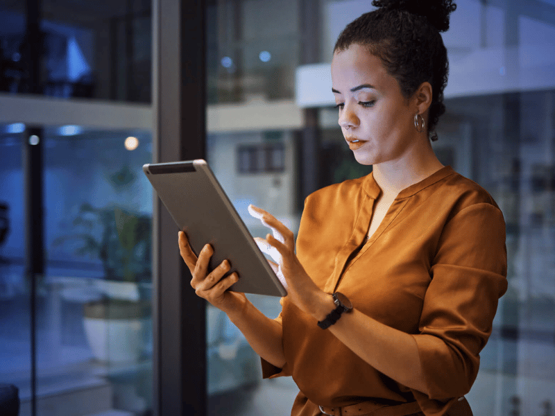Business woman standing in office while holding a tablet